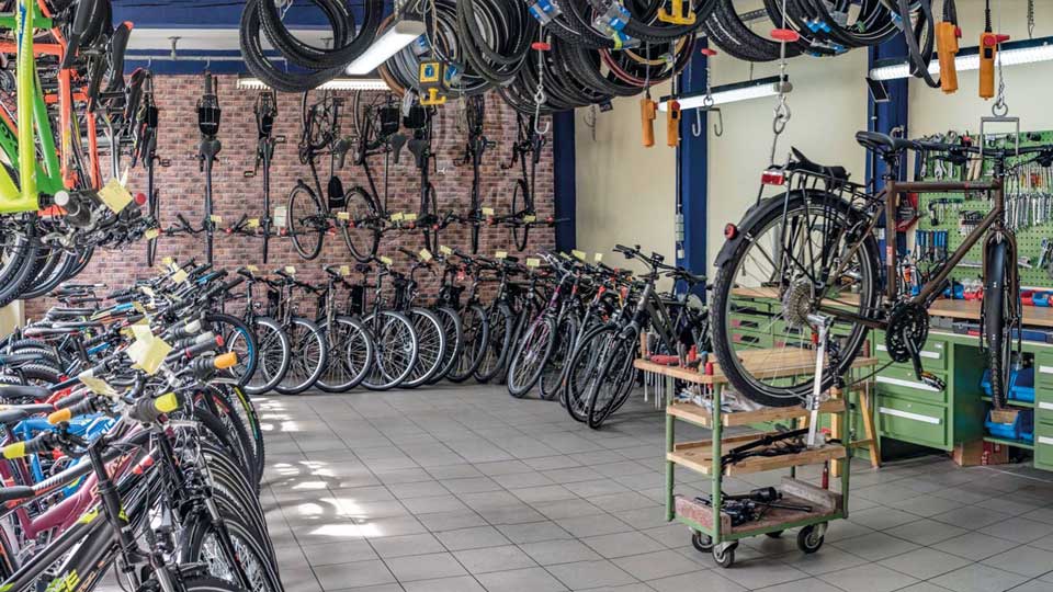 Auf dem Bild siehst du die einladende Innenansicht von "Rudis Radladen" – einem Fahrradladen mit angeschlossener Werkstatt. Der Raum strahlt eine freundliche Atmosphäre aus und ist der perfekte Ort für alle Fahrradliebhaber und -enthusiasten.