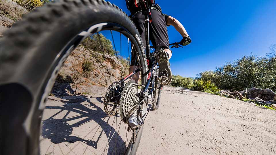 Auf dem Bild ist ein begeisterter Fahrradfahrer zu sehen, der mit seinem Dirtbike eine aufregende Dirtbike-Strecke befährt. Die Strecke besteht aus abwechslungsreichen Geländeformationen wie Hügeln, Sprüngen, Anliegern und Steilkurven, die speziell für diesen anspruchsvollen Fahrradsport entwickelt wurden.